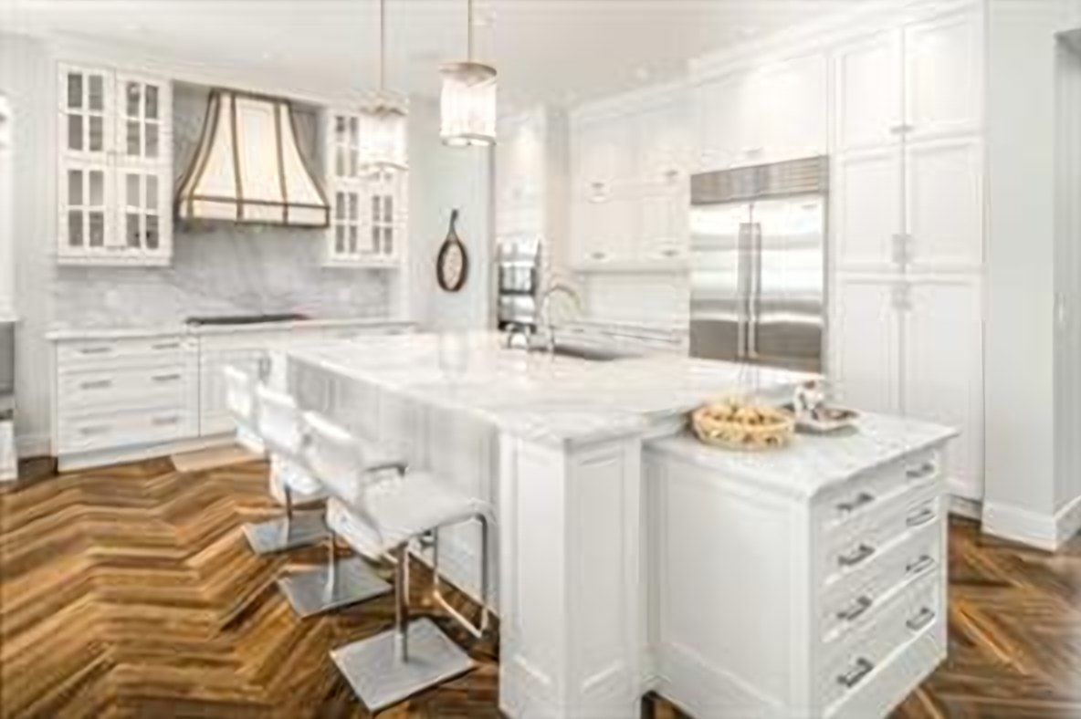 White chef’s kitchen with an oversized marble island, Sub-Zero and Wolf