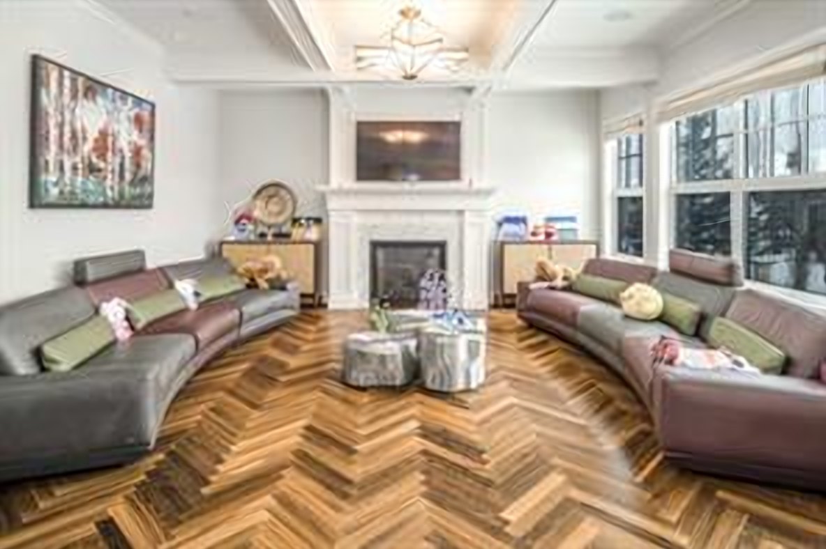 Living room anchored by a gas fireplace, open to the kitchen
