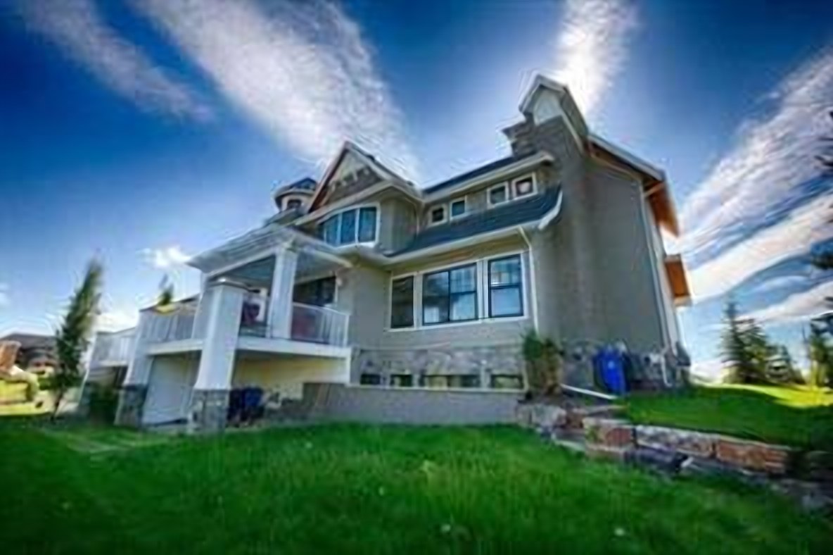 Rear elevation with covered balconies over the walkout and landscaped yard